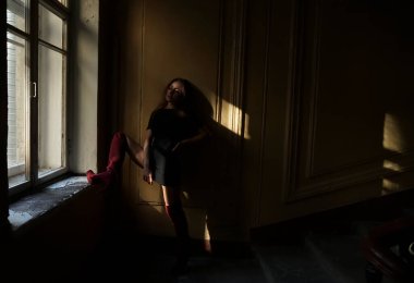 Pencere kenarında duran uzun saçlı, rüya gören bir kadın.. 