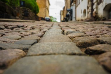 Taş ve güneş ışığı. Eski sokak zemininde asfalt var. Avrupa 'da sokak fayansları ve yürüyen insanlar. Kaldırımlar. Avrupa 'daki evlere karşı kaldırımlı taşlar. Vyborg, Leningrad bölgesi
