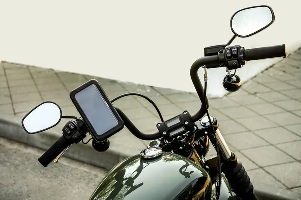 motorcycle with electronic dashboard gps on the steering wheel. mobile phone in cover.