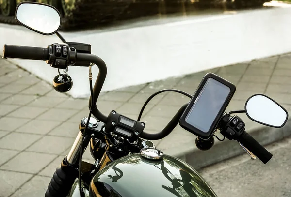 motorcycle with electronic dashboard gps on the steering wheel. mobile phone in cover.