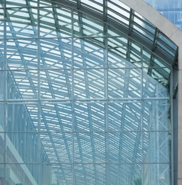 Cam aynalı ofis binasının ön dokusu. Ön cephenin bir parçası. Gündüz vakti iş bölgesindeki modern gökdelenlerin alt manzarası .