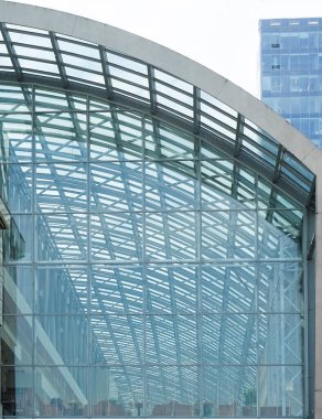 Cam aynalı ofis binasının ön dokusu. Ön cephenin bir parçası. Gündüz vakti iş bölgesindeki modern gökdelenlerin alt manzarası .