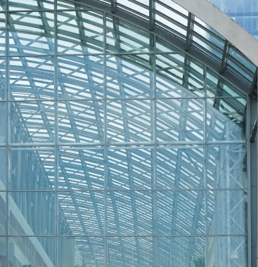 Cam aynalı ofis binasının ön dokusu. Ön cephenin bir parçası. Gündüz vakti iş bölgesindeki modern gökdelenlerin alt manzarası .