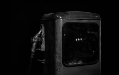 Eski benzin istasyonunun yıllanmış ve yıpranmış fotoğrafı. Yıllanmış ve yıpranmış eski bir benzin pompası. Siyah arkaplanda izole. 