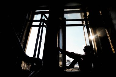 Pencere pervazında oturan rüya gören kadın silueti. Saint Petersburg 'daki eski giriş.