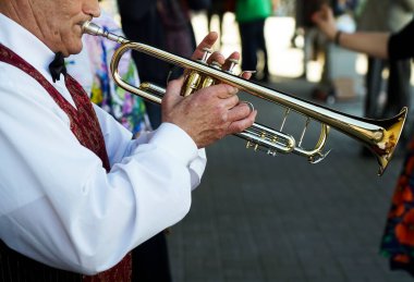 Yaşlı adam trompet çalıyor. Sokak arka planında Flugelhorn olan Caz Müzisyeni. 