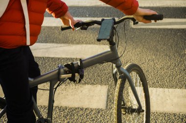Bisiklet GPS Navigator uygulaması ve cep telefonunda harita. Cep telefonundan haritaya bakmak yok. GPS koordinatlarını ara. Gövde Adam, navigatörle bisikletin yanında duruyor. 