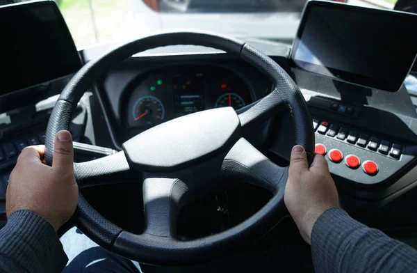 Hands of driver on bus steering wheel. Close up of male hands. The driver is sitting at steering wheel of a bus. top view.