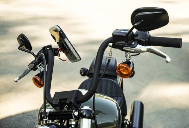 Direksiyonunda elektronik GPS olan bir motosiklet. kapakta cep telefonu.