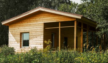 Rusya 'da, ormandaki bir bardan yazlık ev inşaatı. Plastik pencereli ahşap kulübe. Duvarlar güzel ahşaptan yapılmıştır.