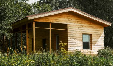 Rusya 'da, ormandaki bir bardan yazlık ev inşaatı. Plastik pencereli ahşap kulübe. Duvarlar güzel ahşaptan yapılmıştır.
