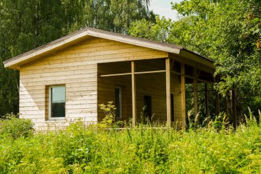 Rusya 'da, ormandaki bir bardan yazlık ev inşaatı. Plastik pencereli ahşap kulübe. Duvarlar güzel ahşaptan yapılmıştır.
