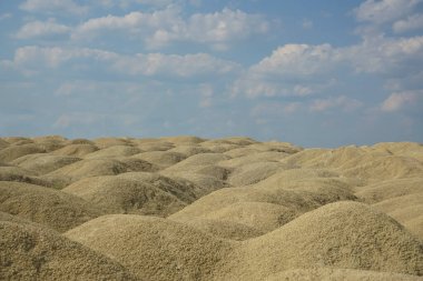 Höyük ve toprak yolun alçak açılı ufuk manzarası. Gökyüzü arkaplan görünümlü toprak çalışma alanı