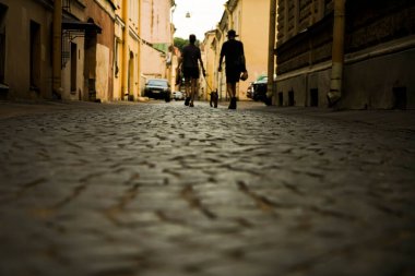 Köpeği tasmayla dolaştırmak. Şehir parke taşı. kaldırım taşları üzerinde yürüyen yayaların silueti. Saint Petersburg, Rusya.