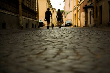 Köpeği tasmayla dolaştırmak. Şehir parke taşı. kaldırım taşları üzerinde yürüyen yayaların silueti. Saint Petersburg, Rusya.