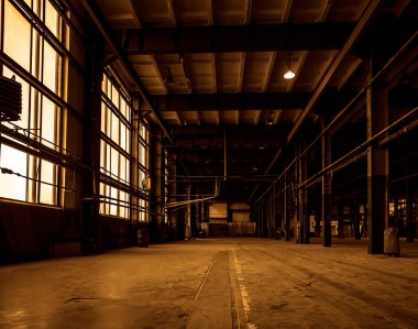 Büyük pencereli eski terk edilmiş fabrika koridorunun içi. boş çelik yapı atölyesi, terkedilmiş fabrika binaları veya depo arka planı