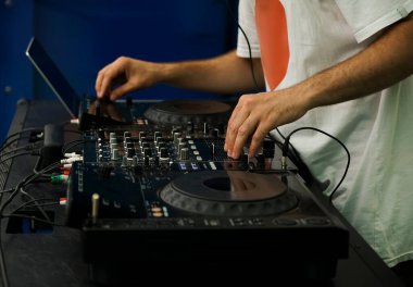 Hip hop DJ 'i kulüpteki partide dijital CD pikaplarda müzik parçalarını eşeliyor. Disk jokeyi müzikholün sahnesinden canlı yayın yapıyor. 