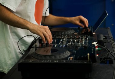 Hip hop DJ 'i kulüpteki partide dijital CD pikaplarda müzik parçalarını eşeliyor. Disk jokeyi müzikholün sahnesinden canlı yayın yapıyor. 