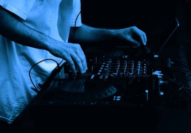 Hip hop DJ 'i kulüpteki partide dijital CD pikaplarda müzik parçalarını eşeliyor. Disk jokeyi müzikholün sahnesinden canlı yayın yapıyor. 