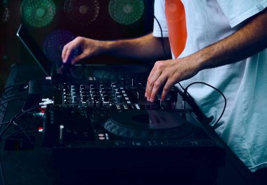 Hip hop DJ 'i kulüpteki partide dijital CD pikaplarda müzik parçalarını eşeliyor. Disk jokeyi müzikholün sahnesinden canlı yayın yapıyor. 