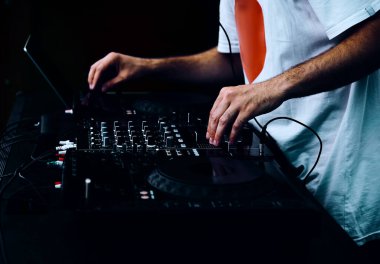 Hip hop DJ 'i kulüpteki partide dijital CD pikaplarda müzik parçalarını eşeliyor. Disk jokeyi müzikholün sahnesinden canlı yayın yapıyor. 