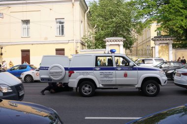 Saint Petersburg 15 Temmuz 2021: Polis memuru iyi giyimli birini kelepçeleyip tutukladı. şüpheli.