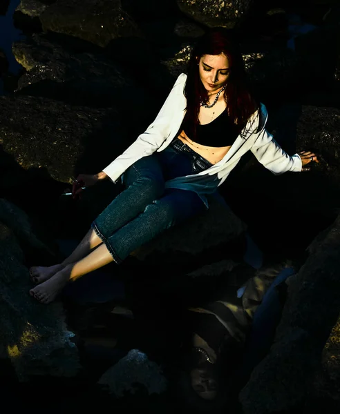 少女はタバコで夏の日に大きな石の上に座っていました 水の中で — ストック写真
