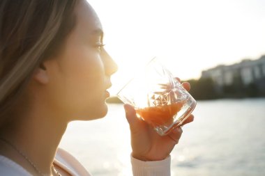 Tatilde. Yaz gezisi. Sahildeki kadın. Yakın görüş. Yazlık Terasta Portakal Suyu İçen Genç Kız, Rahatlayan Güzel Kadın. Doğal güneşli ışık 