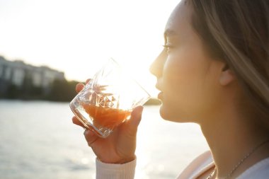 Tatilde. Yaz gezisi. Sahildeki kadın. Yakın görüş. Yazlık Terasta Portakal Suyu İçen Genç Kız, Rahatlayan Güzel Kadın. Doğal güneşli ışık 