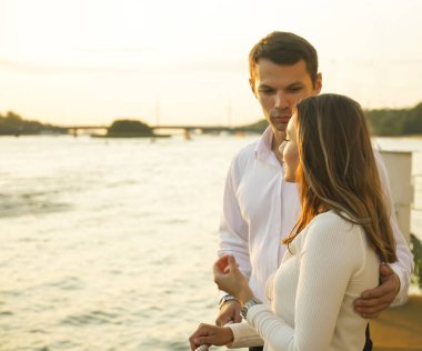 Genç çift güneşli bir günde sahilde sarılıp yürüyorlar. Birbirine aşık çiftler el ele tutuşup birbirlerine bakarlar. Sahil şeridinde bekleyen çift, boş kopya alanı.