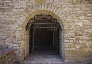 Antik kale sarayı. Kale kulesi ve kapı kapısı. Kale duvarları ve kapı izole edilmiş. Saray kalesinin arka planında. Taş mimarisi Dev metal kapı 