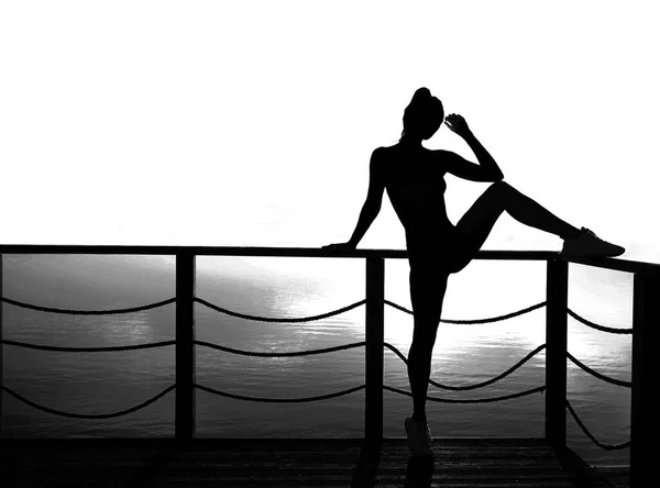 在波罗的海日落的背景下 一个活泼性感的女人 冥想和放松 — 图库照片