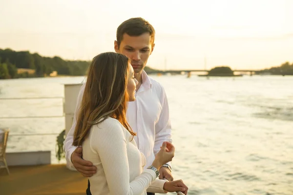 在阳光灿烂的日子里 一对年轻夫妇在海滨拥抱和散步 恋爱中的夫妻手牵手互相望着对方 站在海岸线上的情侣 空旷的复制空间 — 图库照片