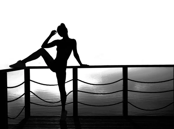 在波罗的海日落的背景下 一个活泼性感的女人 冥想和放松 — 图库照片