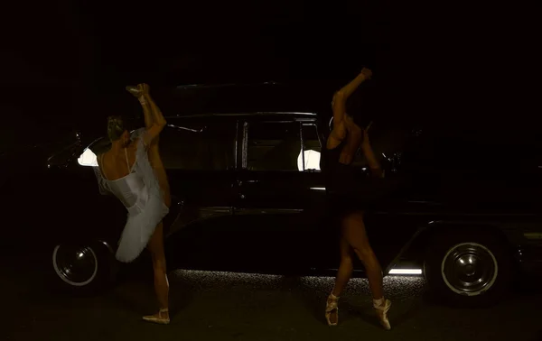 レトロな車の近くで夜に踊る二人のバレエダンサーの肖像 — ストック写真