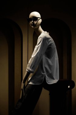 Kafasında güneş gözlüğü olan beyaz gömlekli bir kadın manken.. 