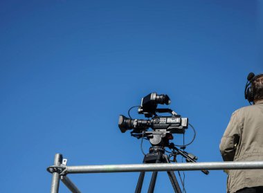 Kameraman çekim yapıyor. Hava gösterisi sırasında çekim yapan bir adam. Kameraman televizyon için çekim yapıyor. canlı biçim.
