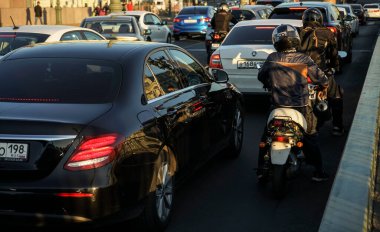  Trafik sıkışıklığı, araba akışı. Trafiğin en yoğun olduğu saatte, arabalar Asphalt Yolu 'ndan çıkar. Arkadan bak. Mobiletler yolda..