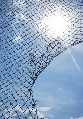 Günbatımı arka planında tel ya da metal ağ, mavi gökyüzü. ağ boşluğu. 