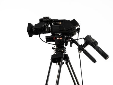 Video kamera beyaz arka planda izole bir şekilde tripodun üzerinde duruyor. Teknoloji konsepti, modern, eğlence.