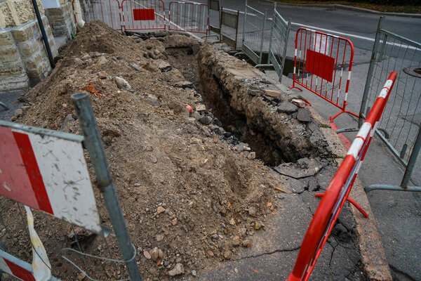 Дорога работает на городской улице. Раскопанная яма. 