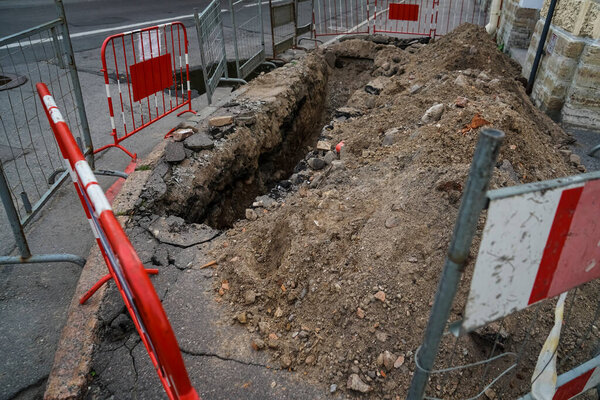 Дорога работает на городской улице. Раскопанная яма. 