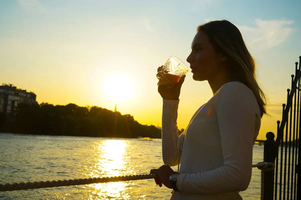 Foto Silhueta Uma Mulher Bebendo Suco Laranja Copo Pôr Sol — Fotografia de Stock