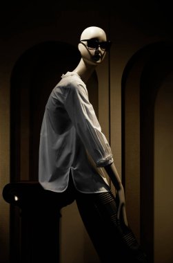 Kafasında güneş gözlüğü olan beyaz gömlekli bir kadın manken.. 