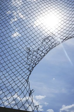 Günbatımı arka planında tel ya da metal ağ, mavi gökyüzü. ağ boşluğu. 