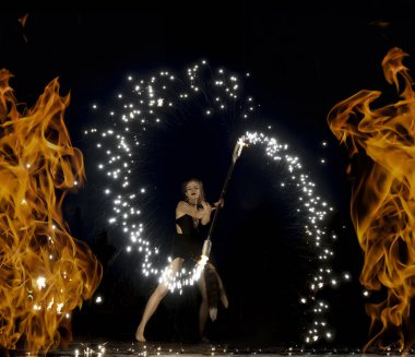 SAINT PETERSBURG, RUSYA - 26 Haziran 2021: Kız alev alev yanan meşaleler çeviriyor. Tehlikeli inanılmaz gece performansı