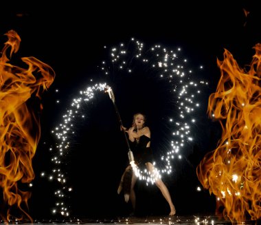 SAINT PETERSBURG, RUSYA - 26 Haziran 2021: Kız alev alev yanan meşaleler çeviriyor. Tehlikeli inanılmaz gece performansı