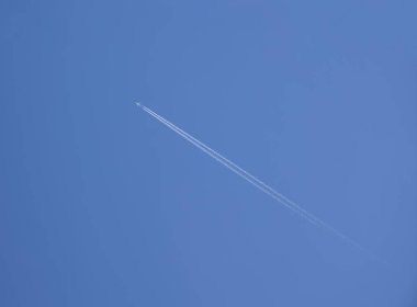Açık mavi gökyüzünde uçan jet uçağının izi.. 