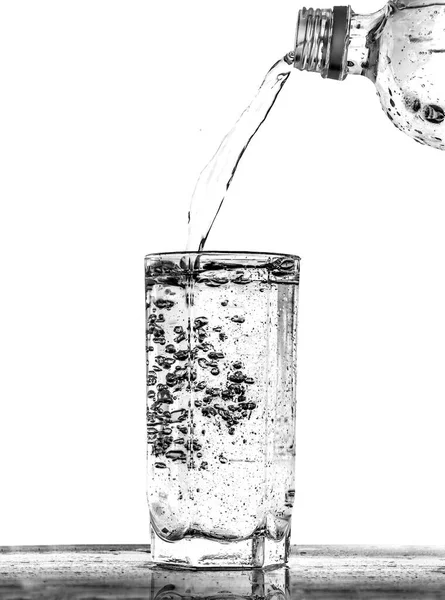 饮用水从塑料瓶中倒入玻璃杯中 — 图库照片