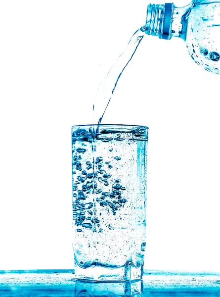 饮用水从塑料瓶中倒入玻璃杯中 — 图库照片